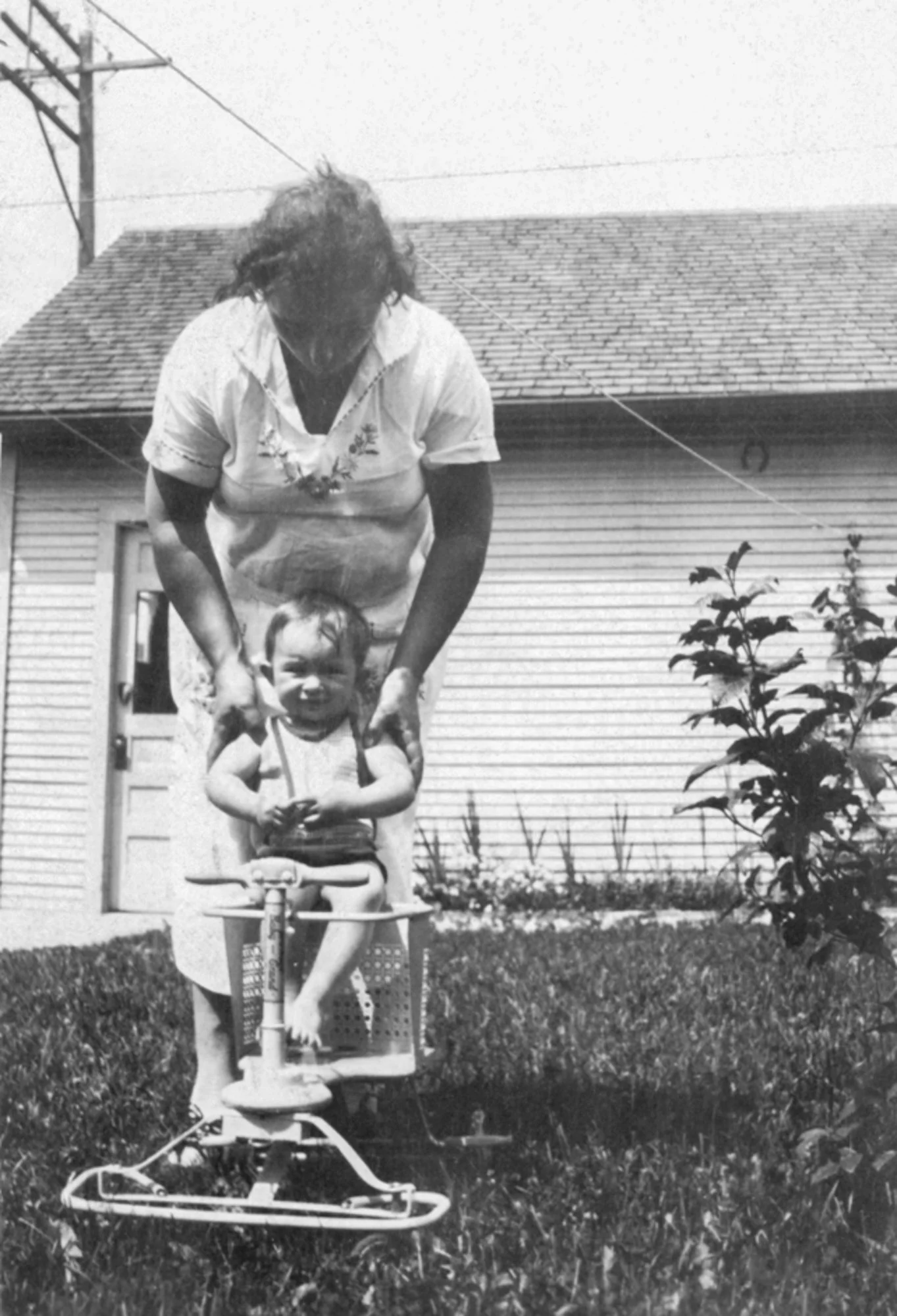 Young Bill in the backyard with his mom