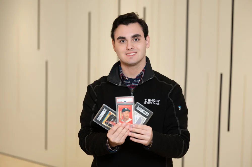 Chris Lambros holding several graded sports cards