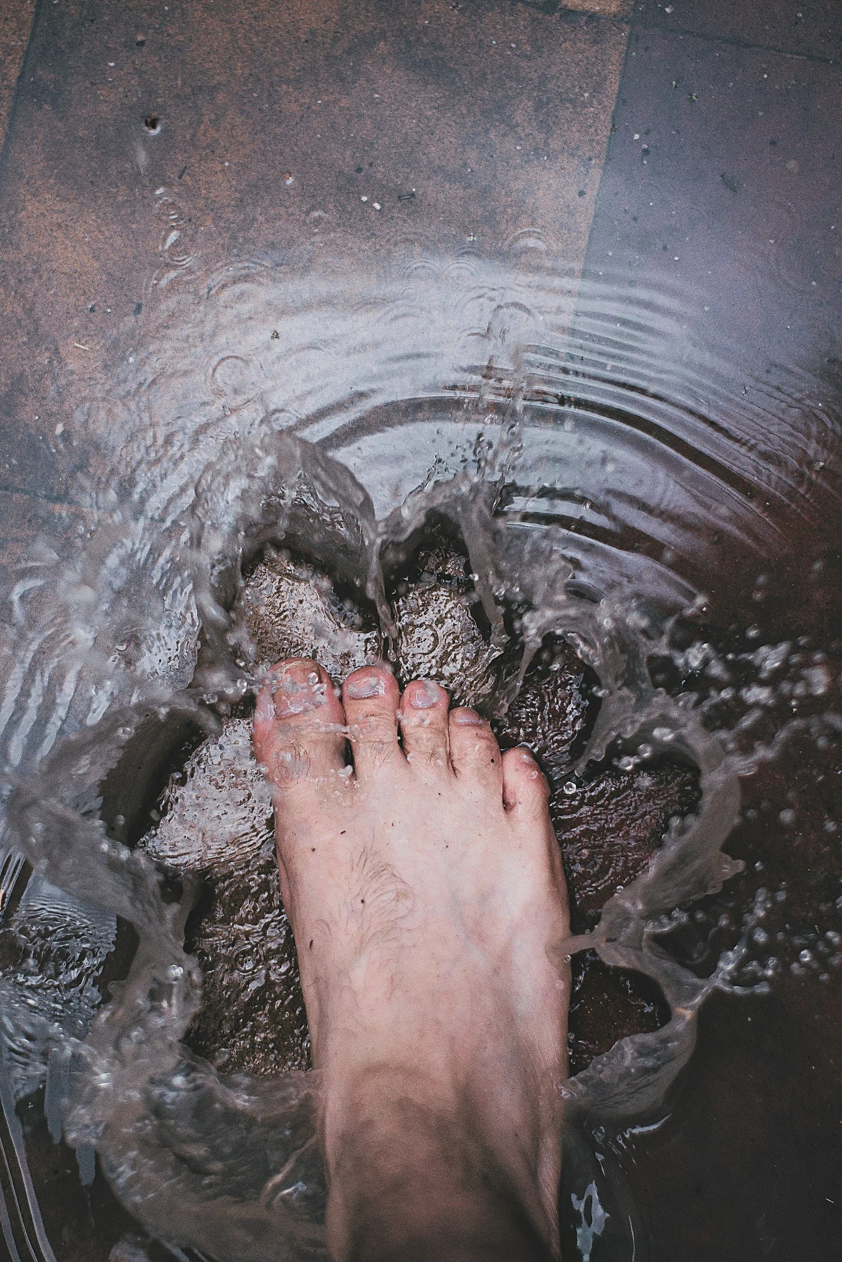 A foot splashes in water implying foot bath and foot soak