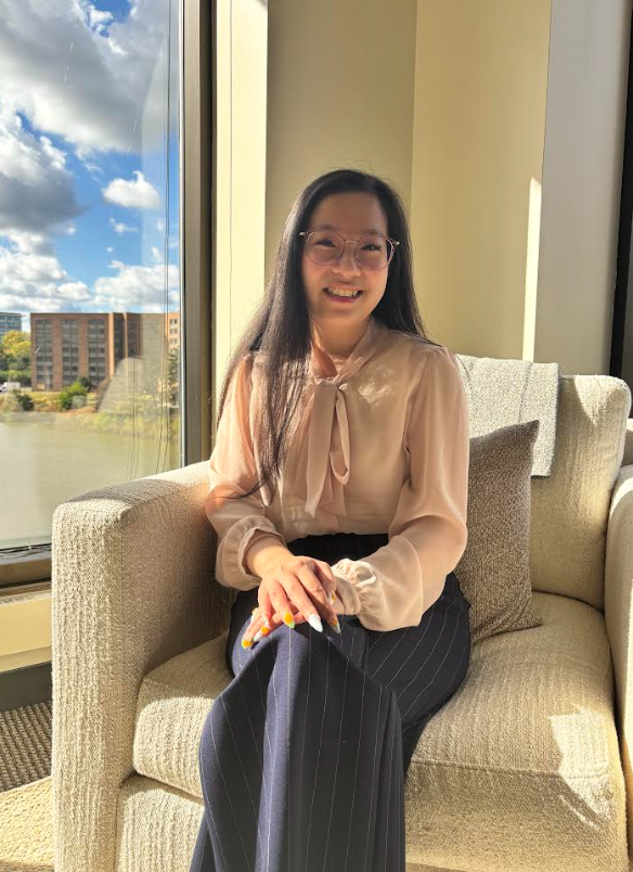 Nhi Vo, an anxiety and trauma therapist in Lisle, IL, sitting in a therapy chair and smiling, providing individual therapy for adults with anxiety, OCD, and long-term emotional pain.