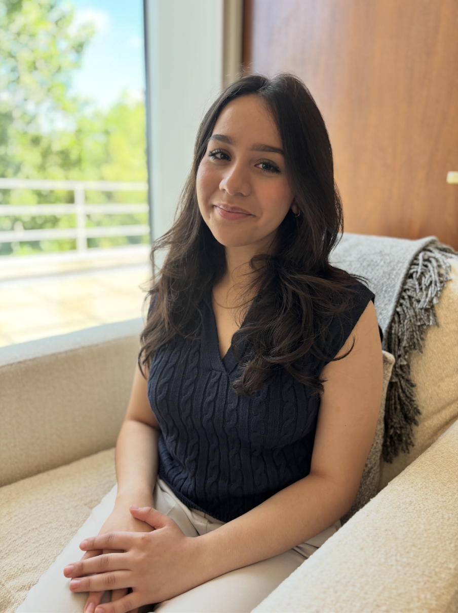 Husnah, client care coordinator at Clove Counseling in Lisle, IL, sitting by a bright window and smiling, welcoming new clients who call or schedule therapy for anxiety, OCD, trauma, and depression