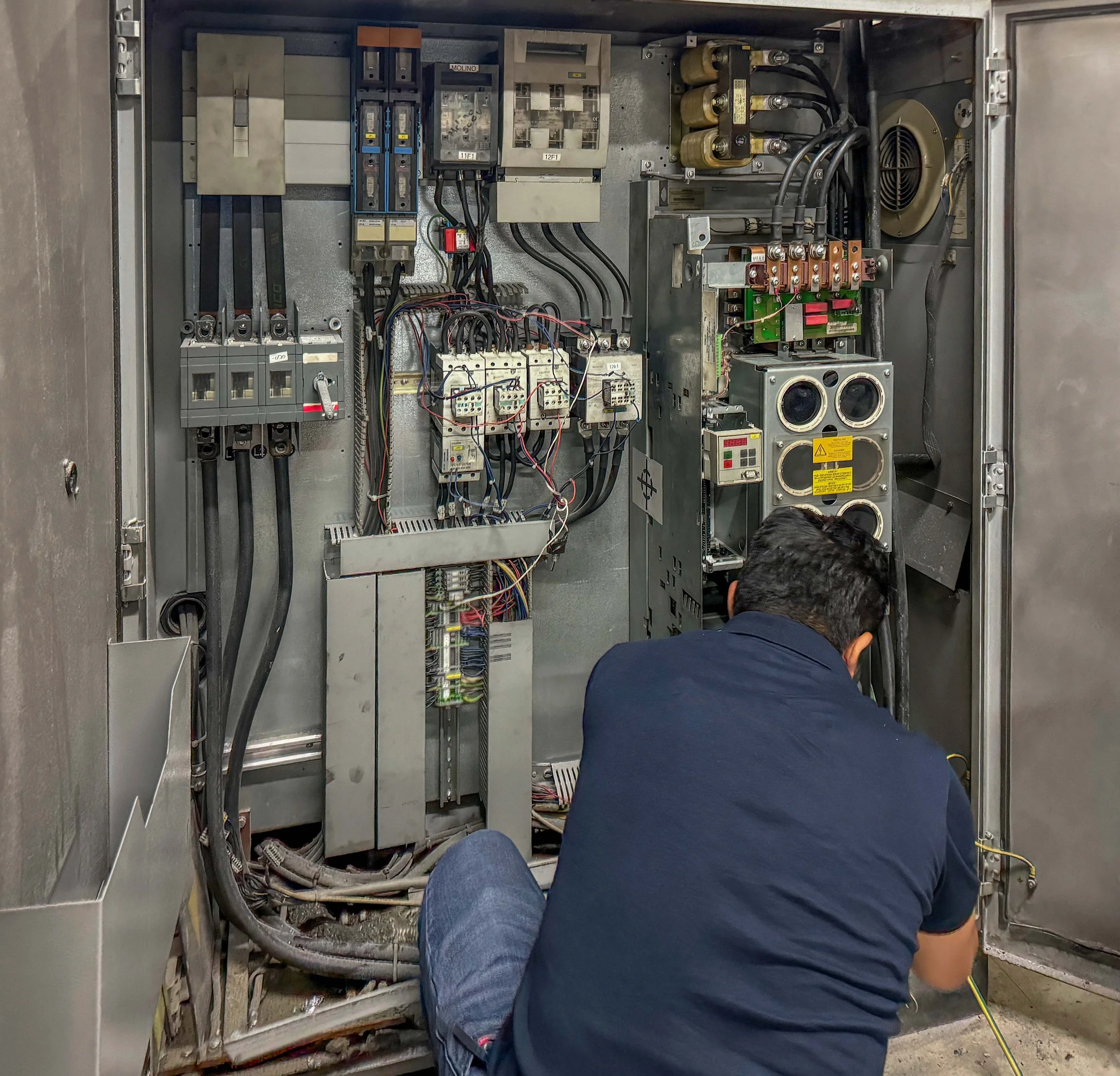 alt="Ingeniero especializado realizando mantenimiento correctivo a un variador de frecuencia (inversor) en una planta de envasado."