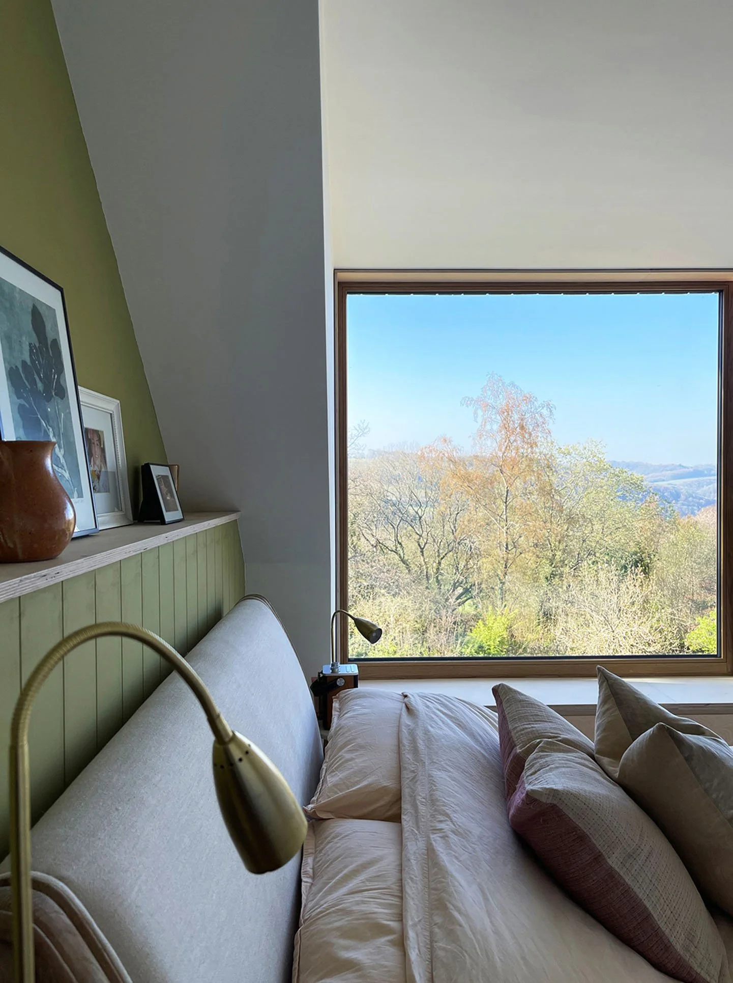 Interior living space framed by large glazed openings, drawing long views towards the southern valley landscape.