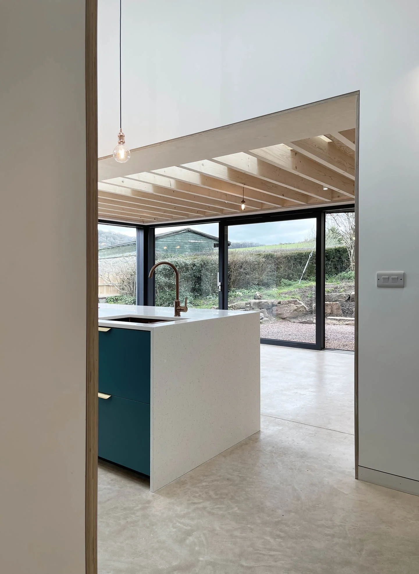 Interior view looking upward to vaulted ceilings and roofline openings that bring daylight deep into the home.