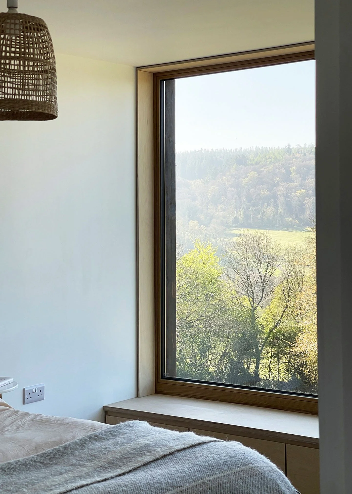 Contemporary bedroom at Lowlands House with a large picture window overlooking the Wye Valley landscape.