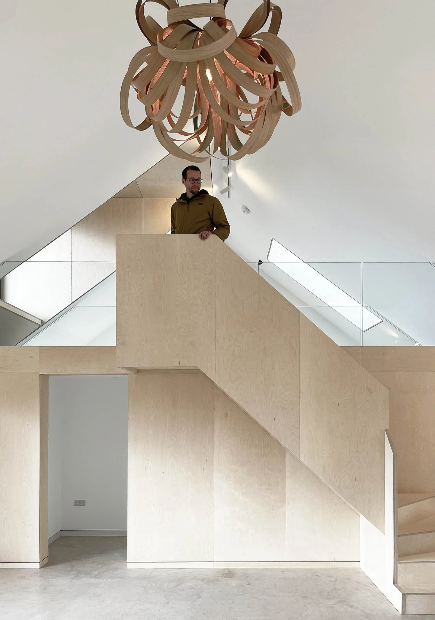 Interior staircase and vertical circulation space with soft daylight filtering through carefully placed openings.