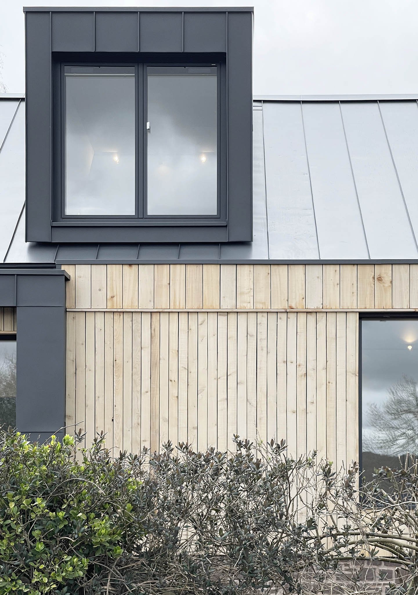 Exterior detail of standing seam metal roofing combined with timber cladding, emphasising the home’s simple, enduring material palette.