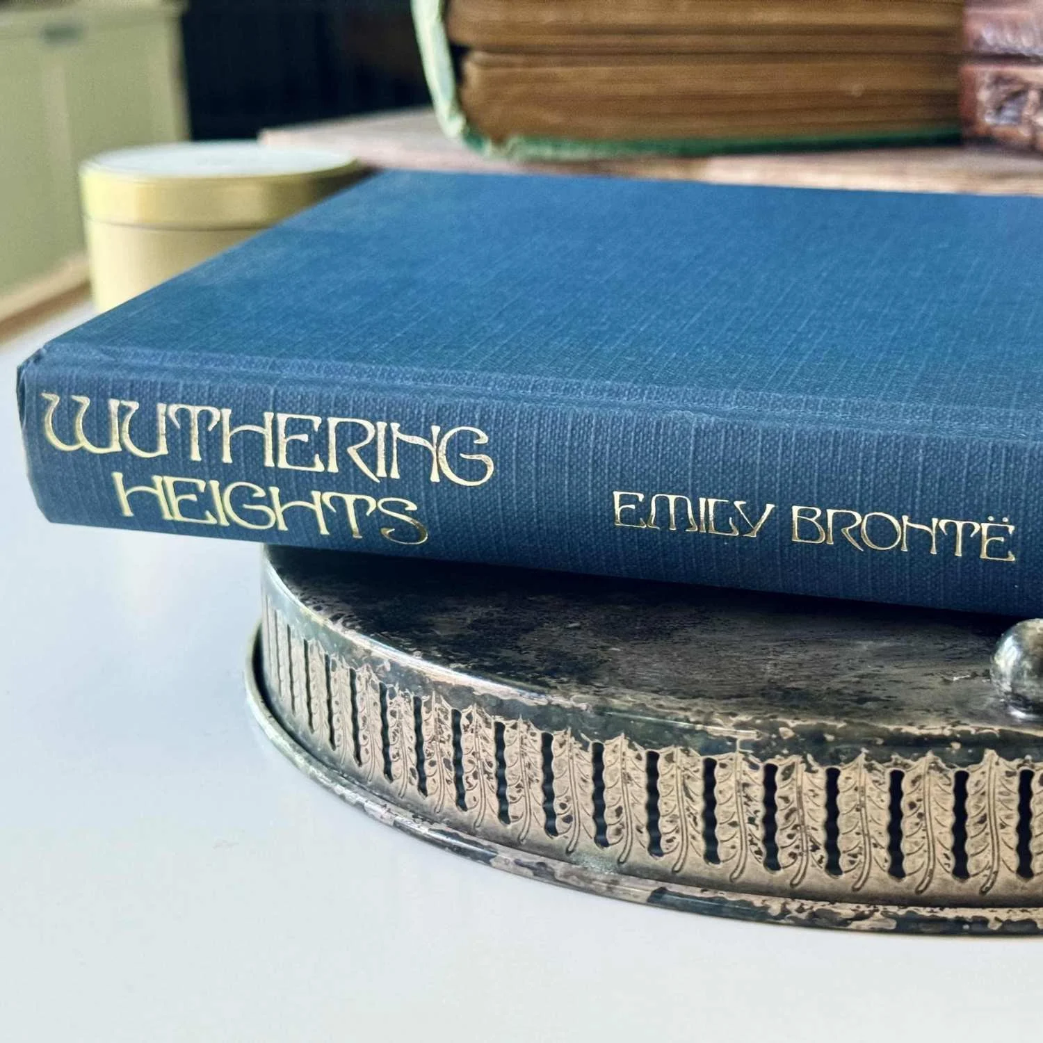 A blue hardcover book laying flat on a metal tray with the spine facing the reader