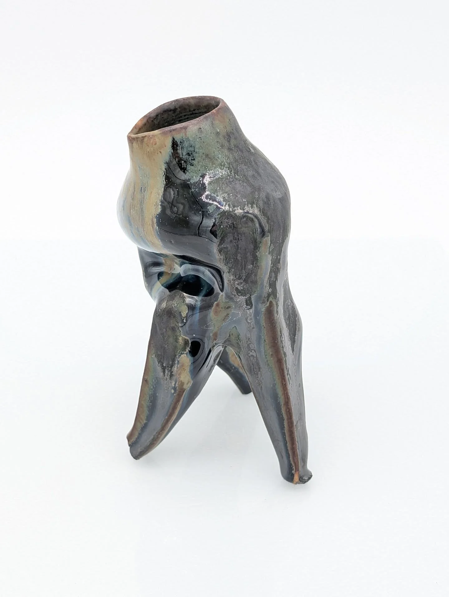 I've been playing with forms a bit more by throwing bottomless on the wheel and altering it. This funky guy has a beautiful iron-rich glaze, and I layered rutile and black copper oxide over it. 

Unfourtunately when you play with chemistry, it can lo