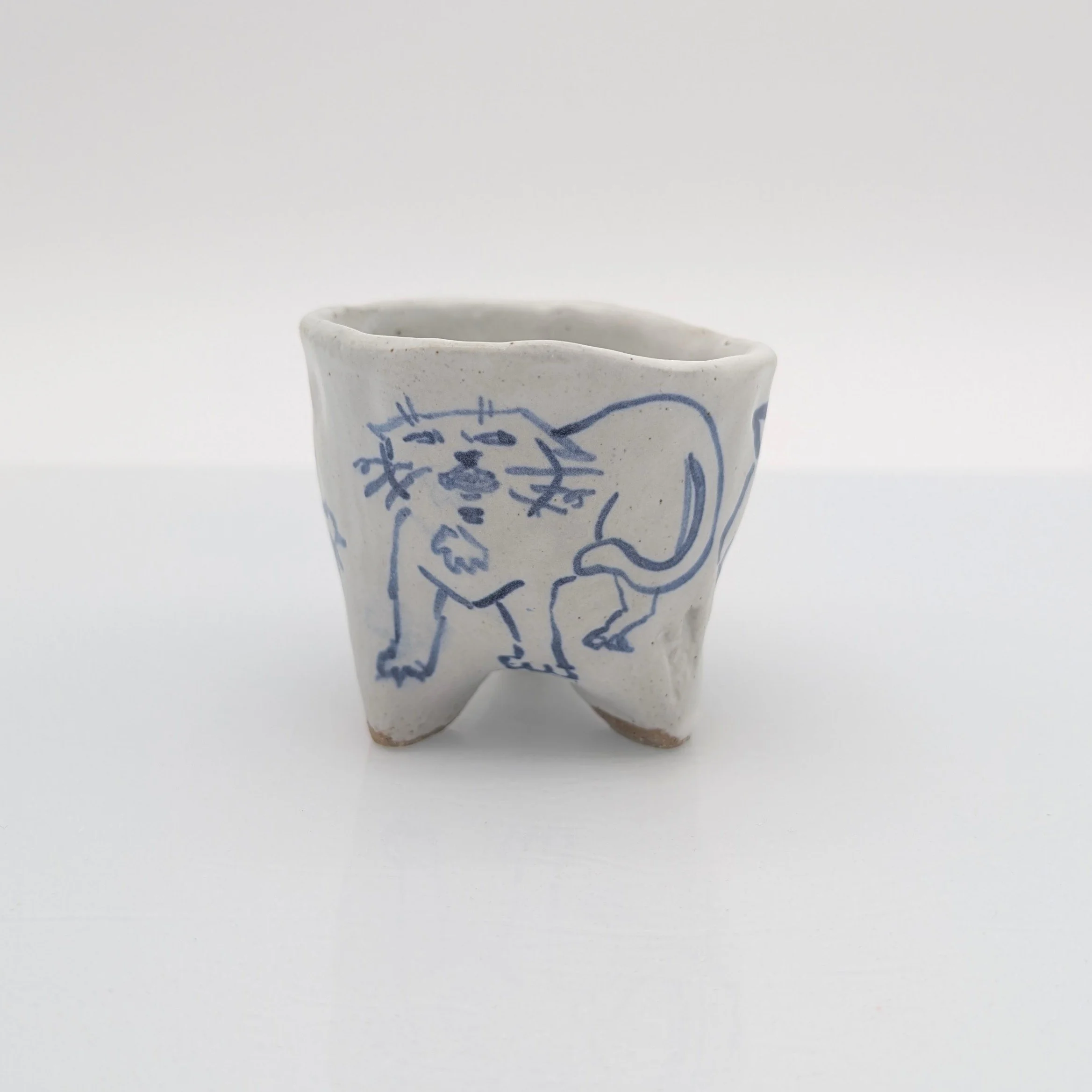 Another little teacup! I had been wanting to try this trifooted base with slab building, pinching together the bottom and I like the stance it gives. The illustrations are inspired by my goblin cat, Lucifer. 
_
#Art #pottery #clay #ceramics #teacup #