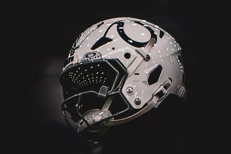 Close-up of a white Colts helmet against a black background.