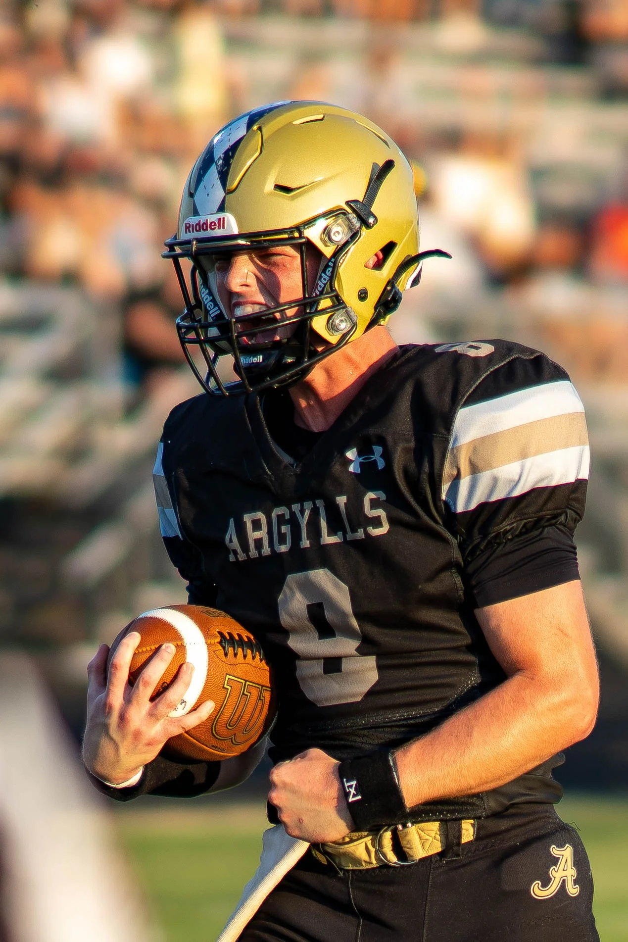 High school football player #9 carrying the ball