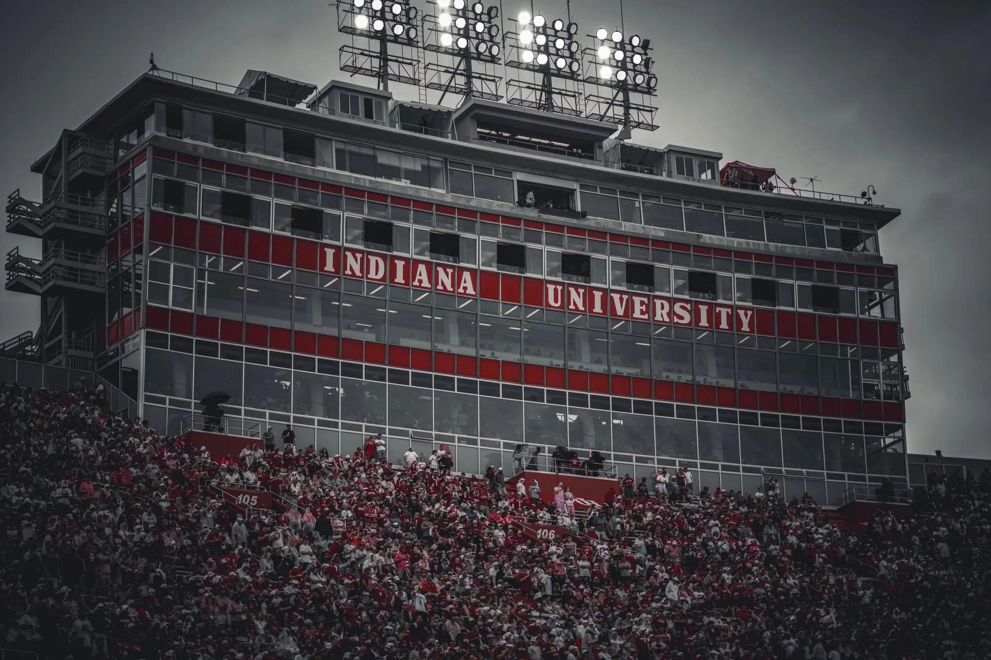 Indiana University press box at Memorial Stadium rising above the crowd under a cloudy sky.