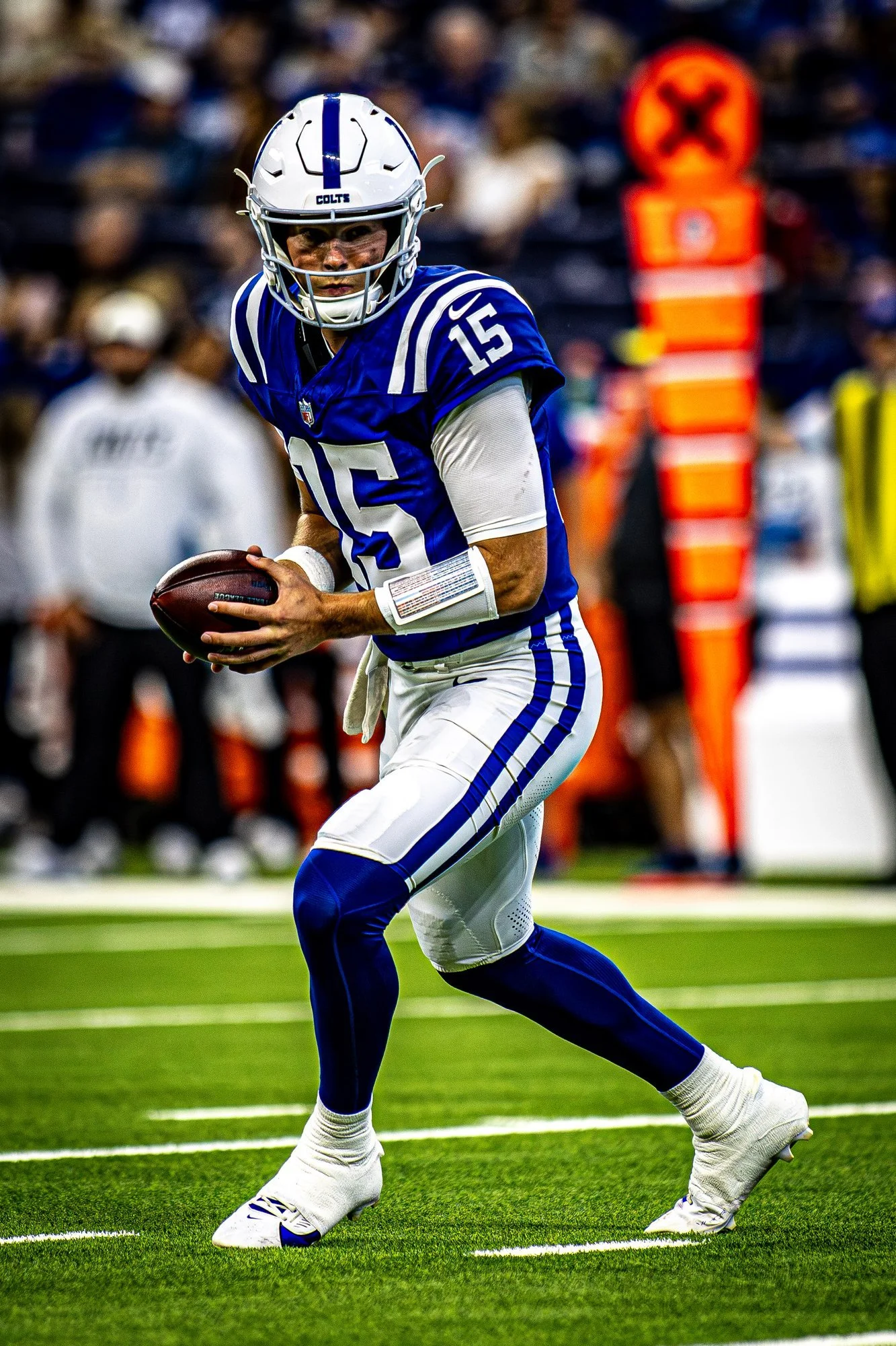 Colts quarterback rolling out with the football looking downfield.