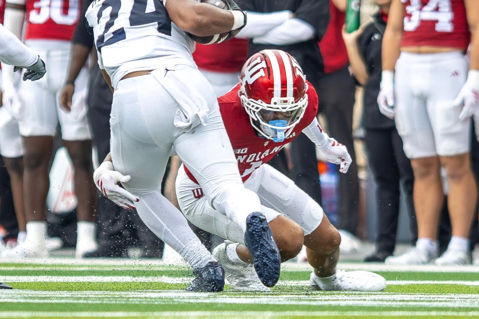 Indiana defender wrapping up an opposing ball carrier near the sideline.