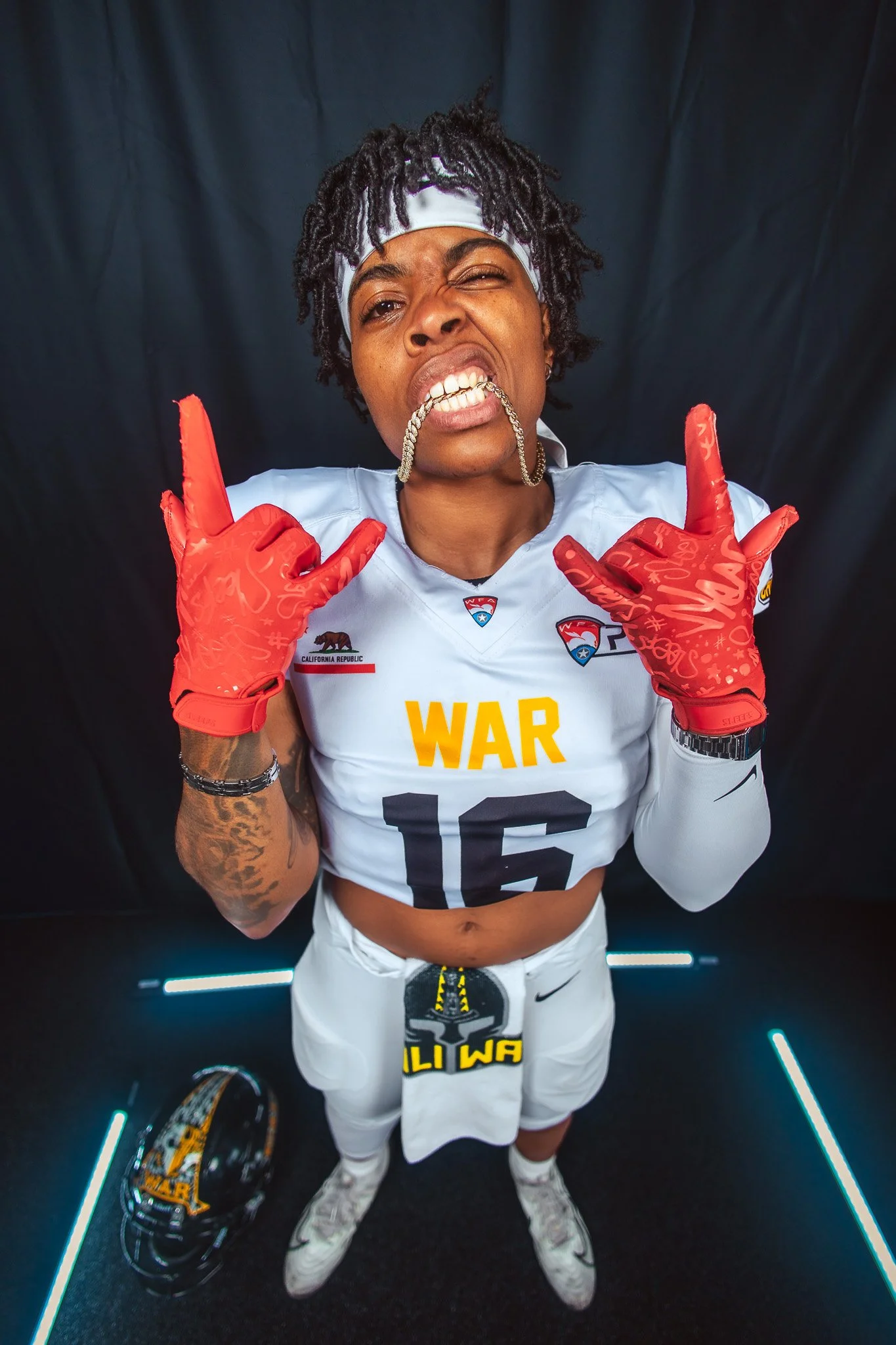 Women's pro football player in #16 WAR jersey poses at media day