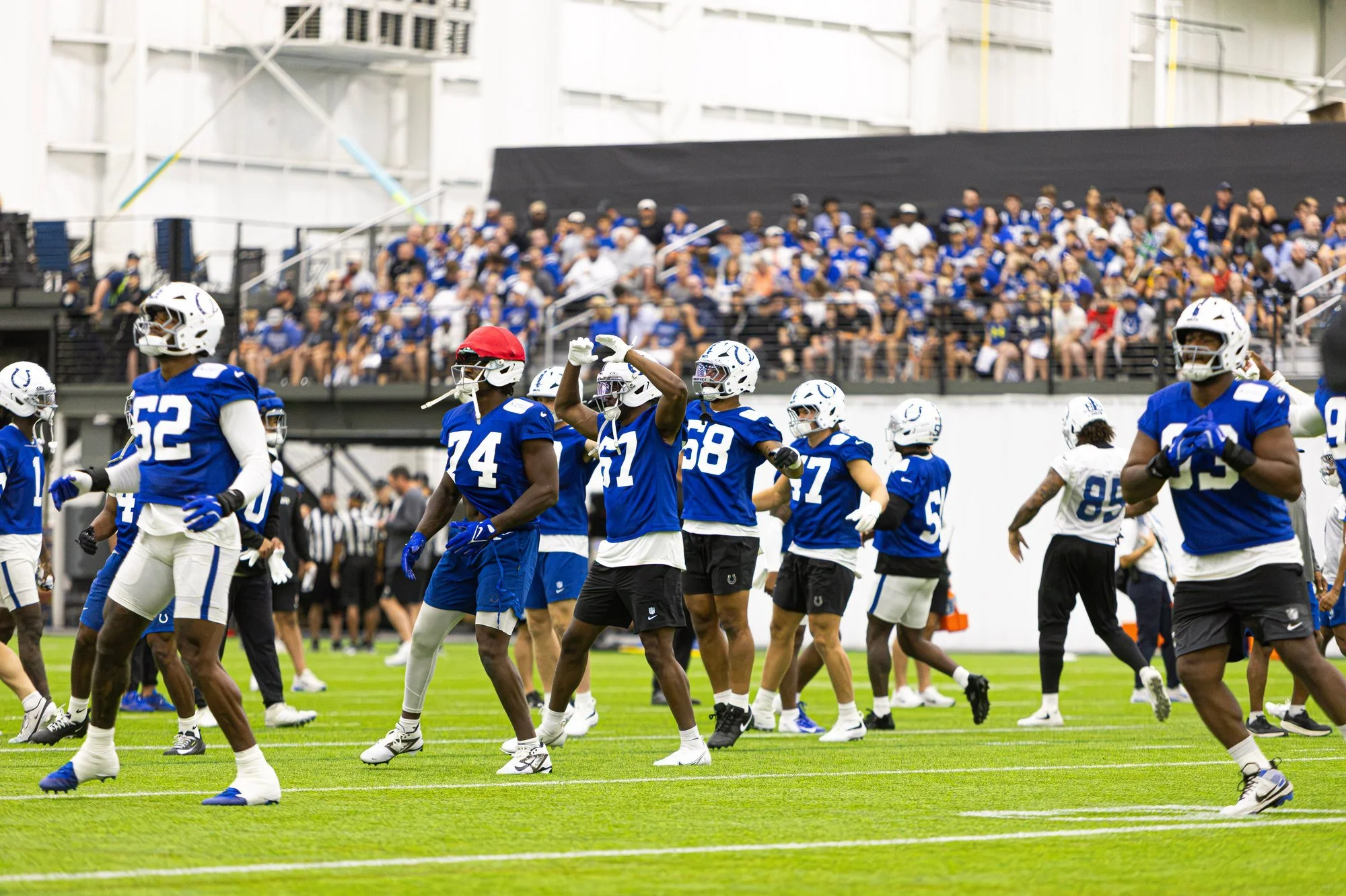 Colts players stretching as a team in front of fans at training camp.