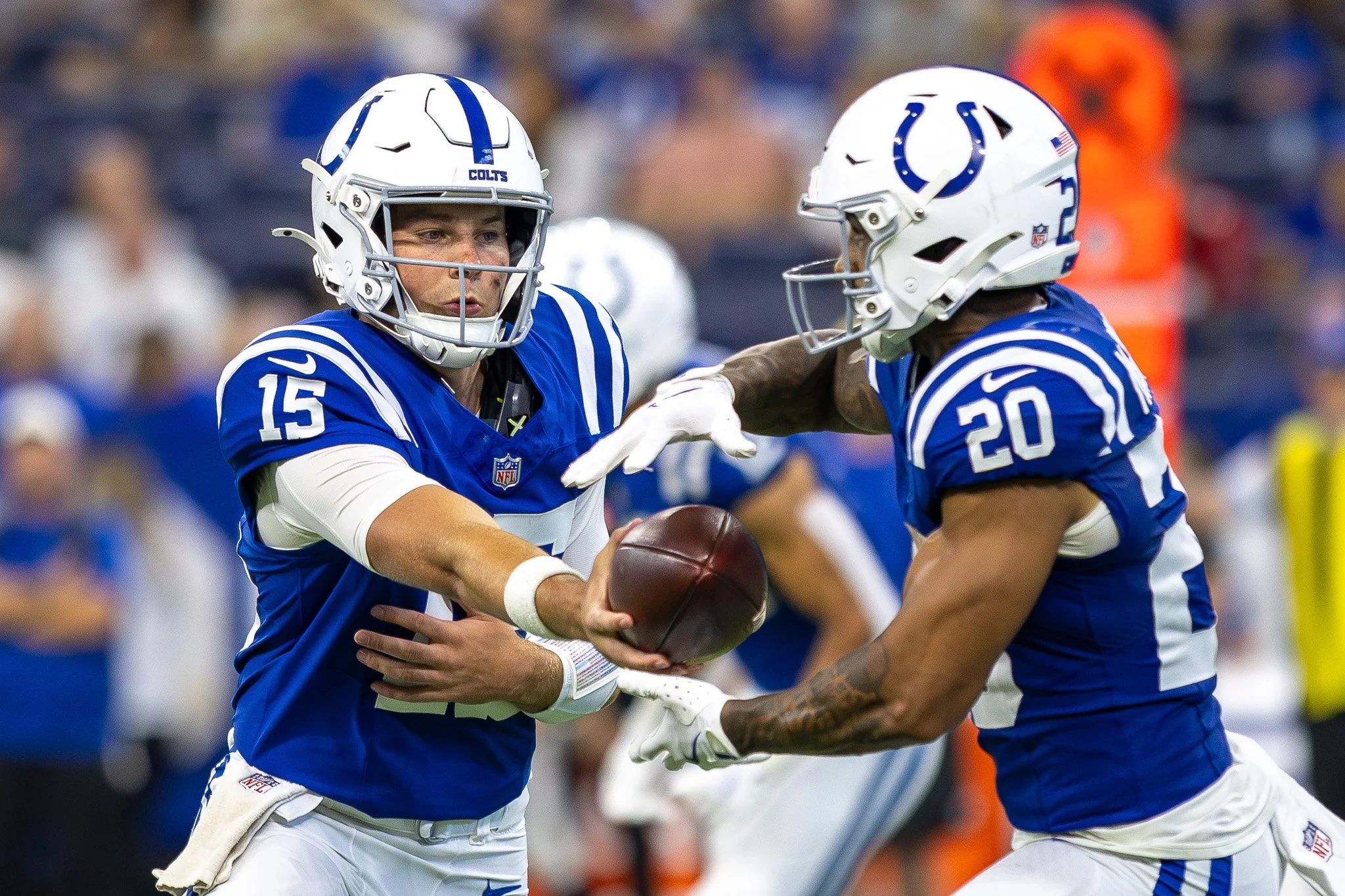 Colts quarterback #15 hands off to running back #20