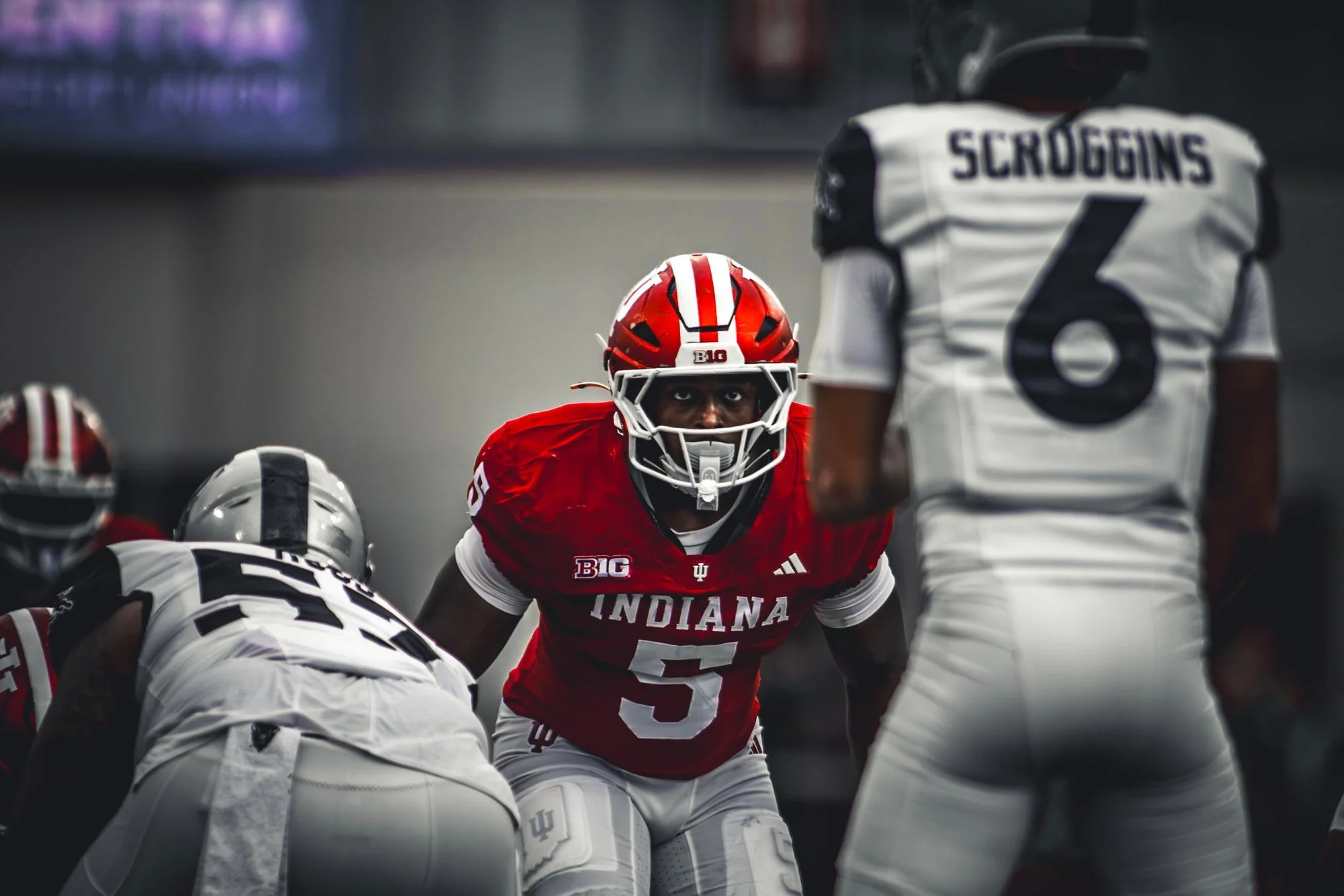 Indiana player in a crimson helmet set at the line of scrimmage before the snap.
