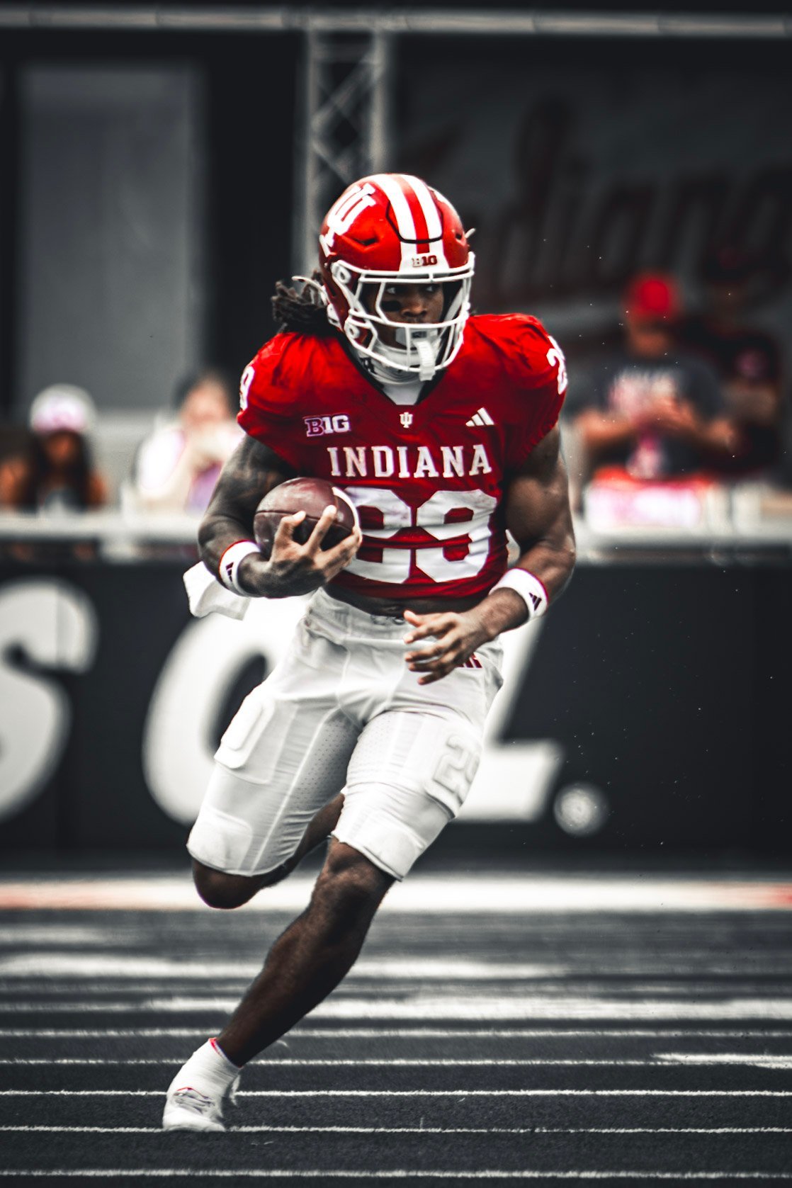 Indiana ball carrier in crimson cutting upfield with the football.