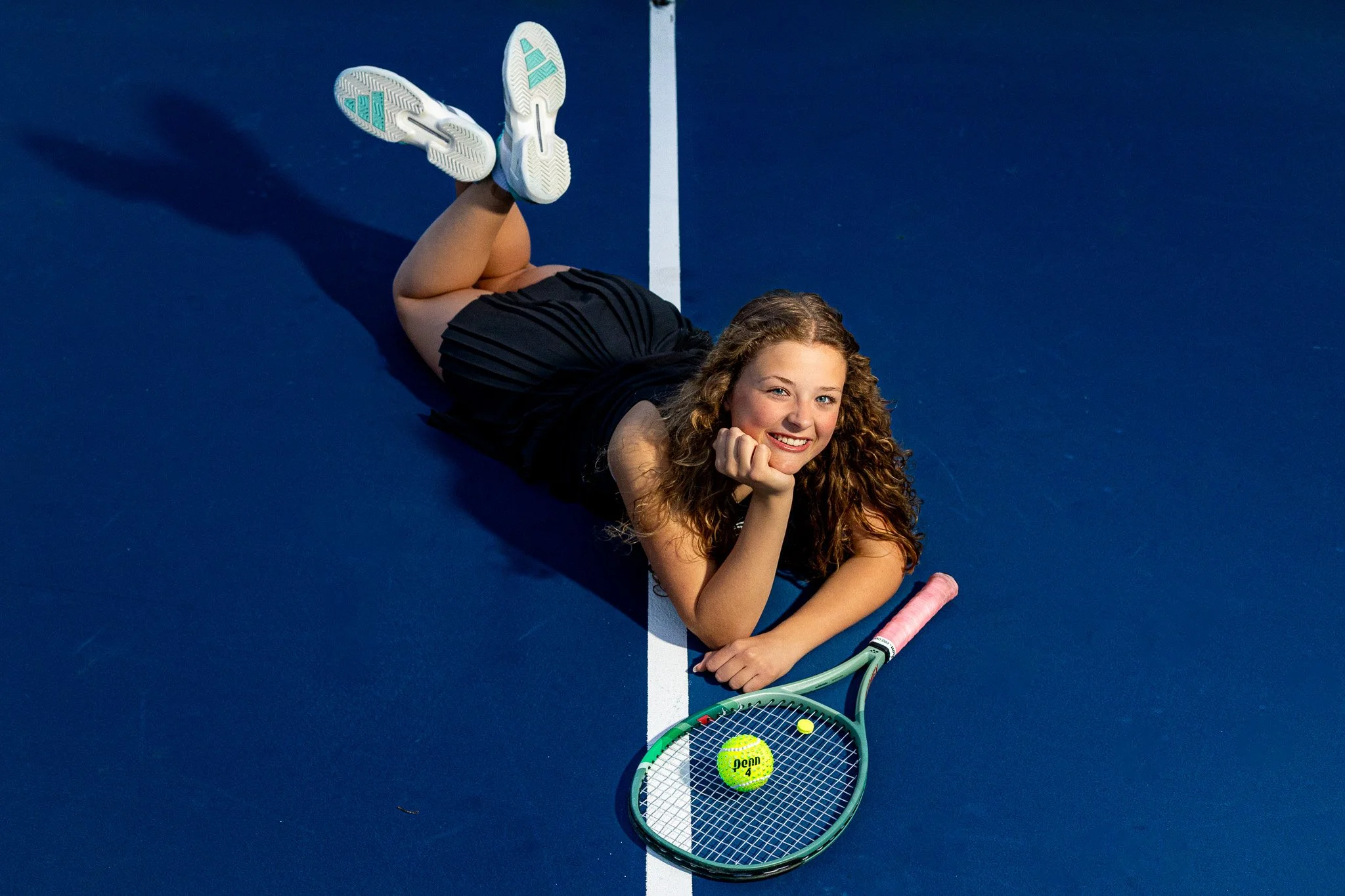 Tennis senior portrait lying on the court with racket