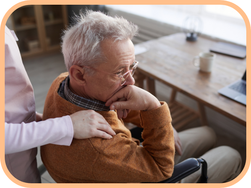 Caregiver offers comfort to an older man sitting at home