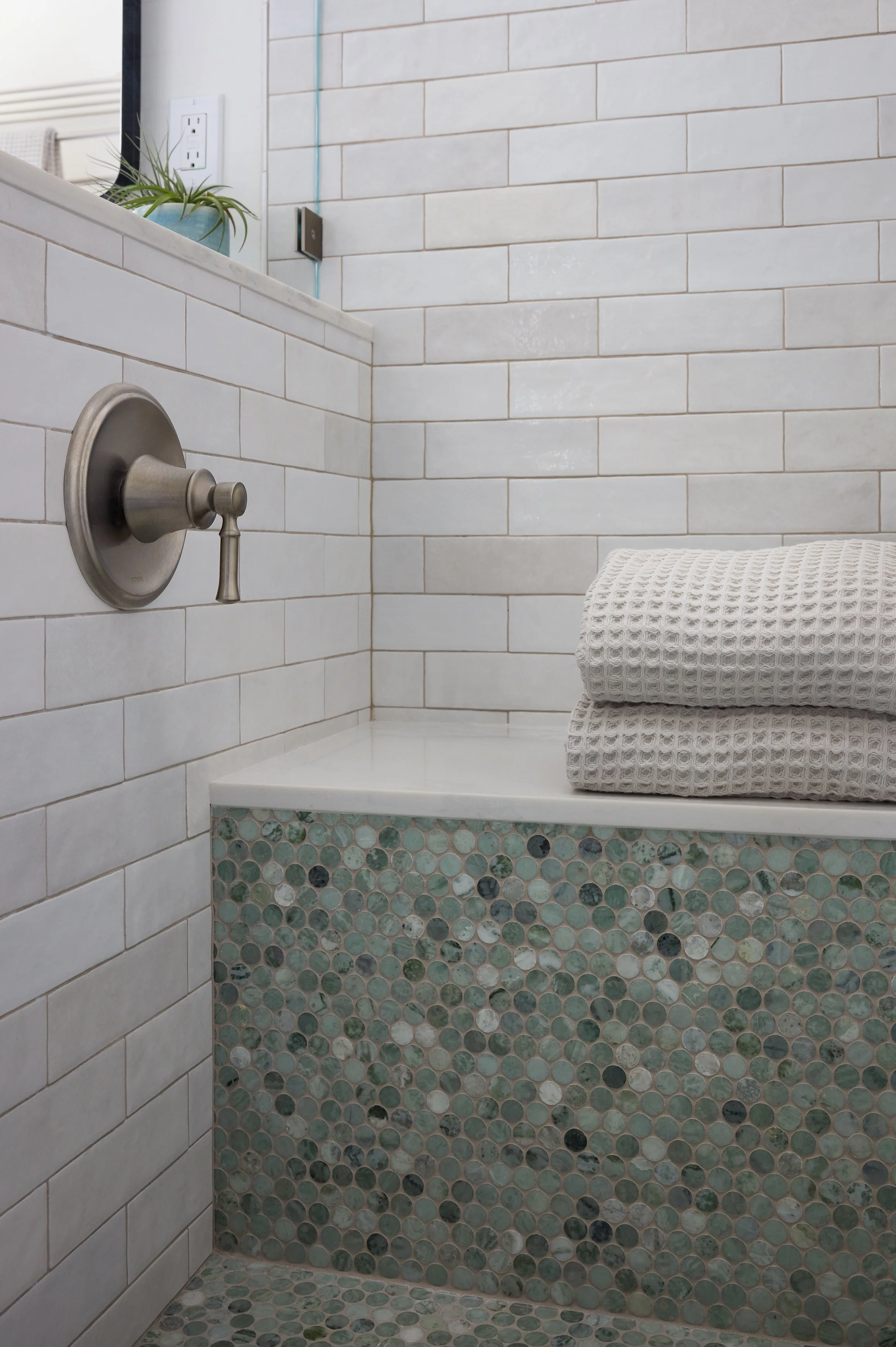 Shower bench designed by Kelsey Brown Interiors. Featuring green marble penny tile, and textured subway tile. 