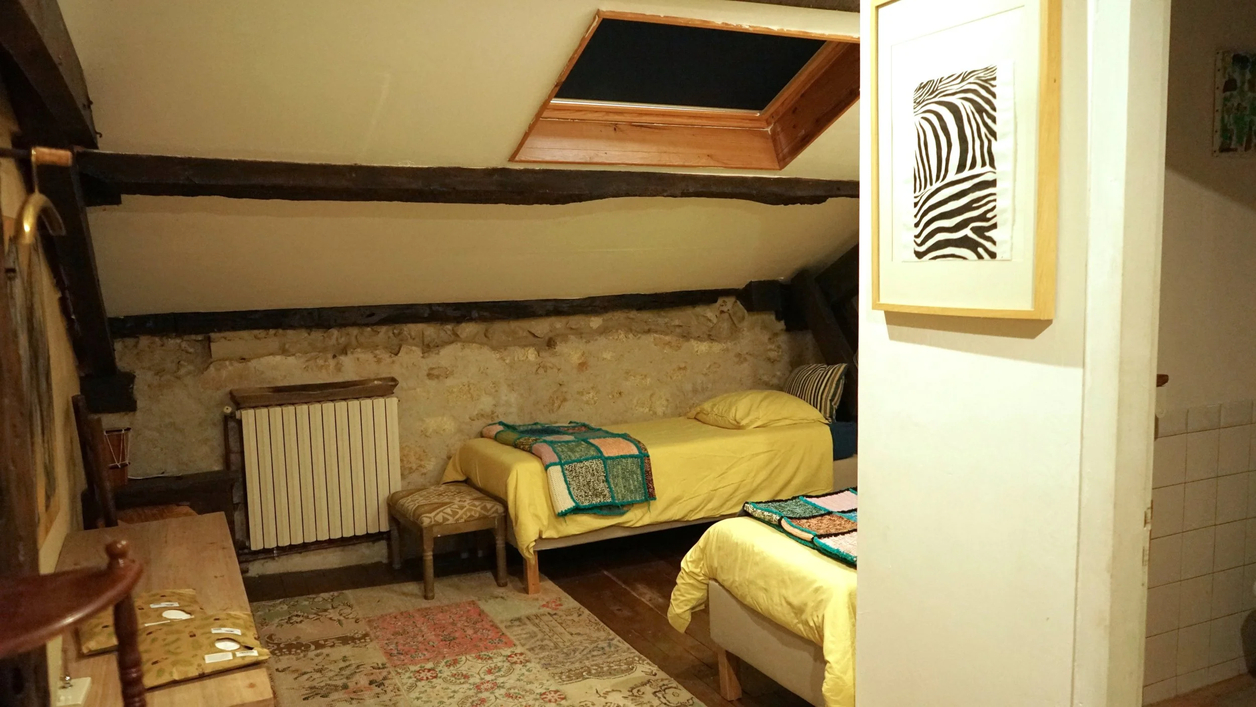 A cozy bedroom with two separate beds in a rustic room