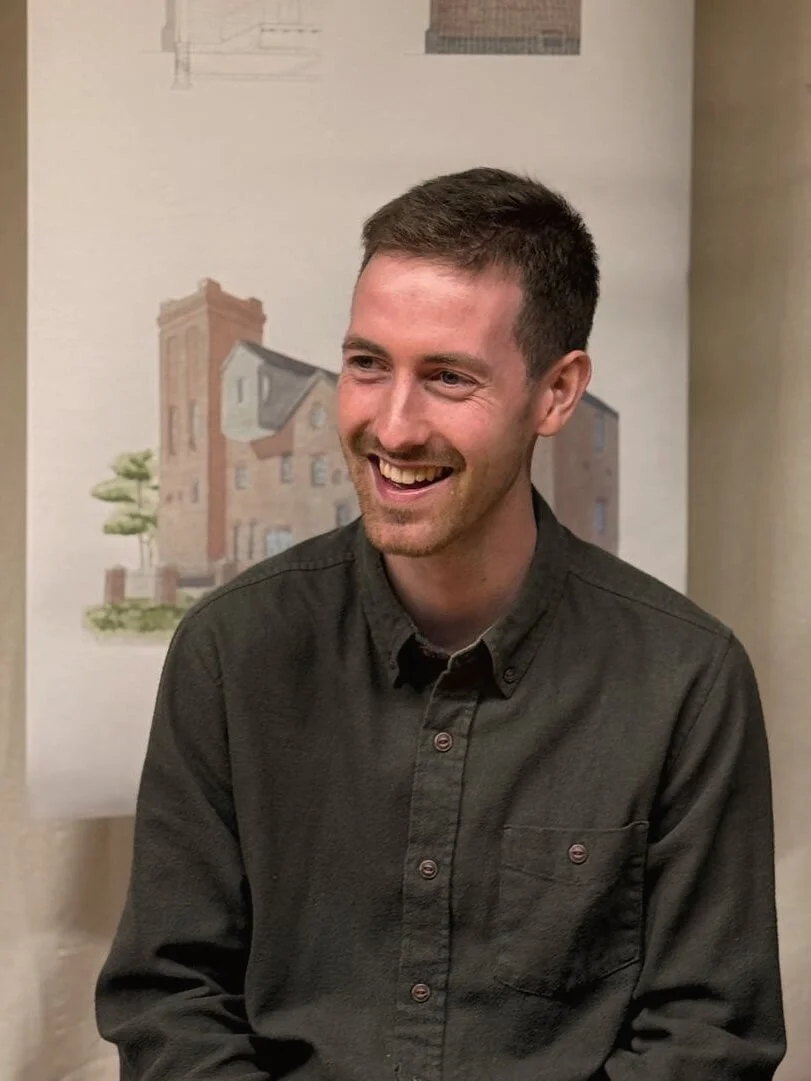 24/Three Senior Architectural Assistant, sitting at a desk smiling