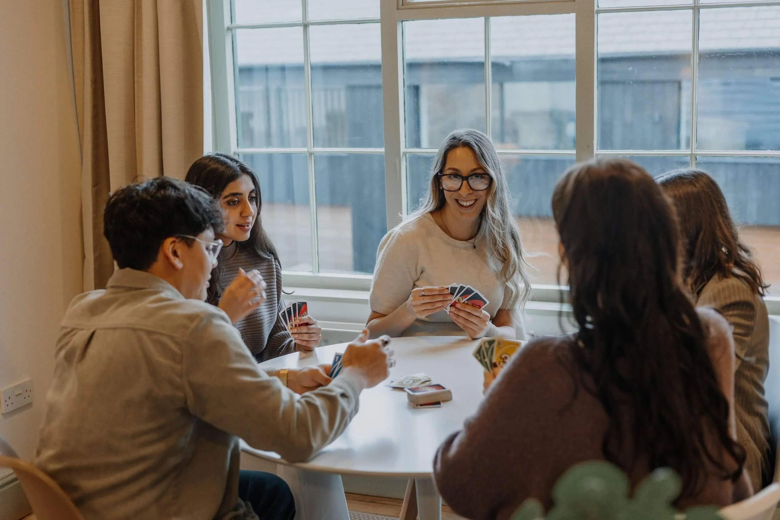 Team members at 24/Three playing UNO in the office breakout space, reflecting the studio’s fun and collaborative work culture.