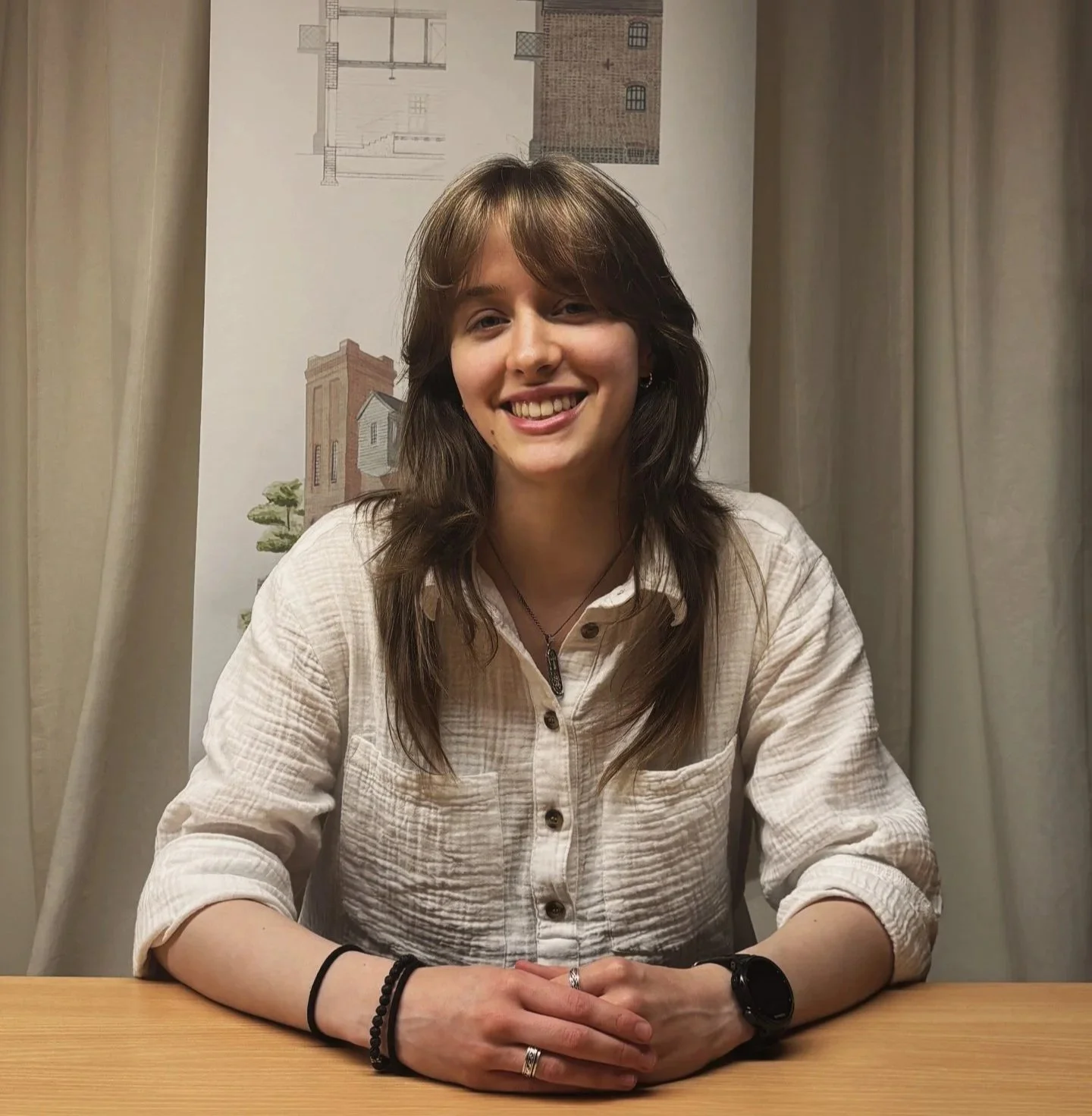 Gemma from 24/three wearing a white linen shirt with brown hair and a black watch
