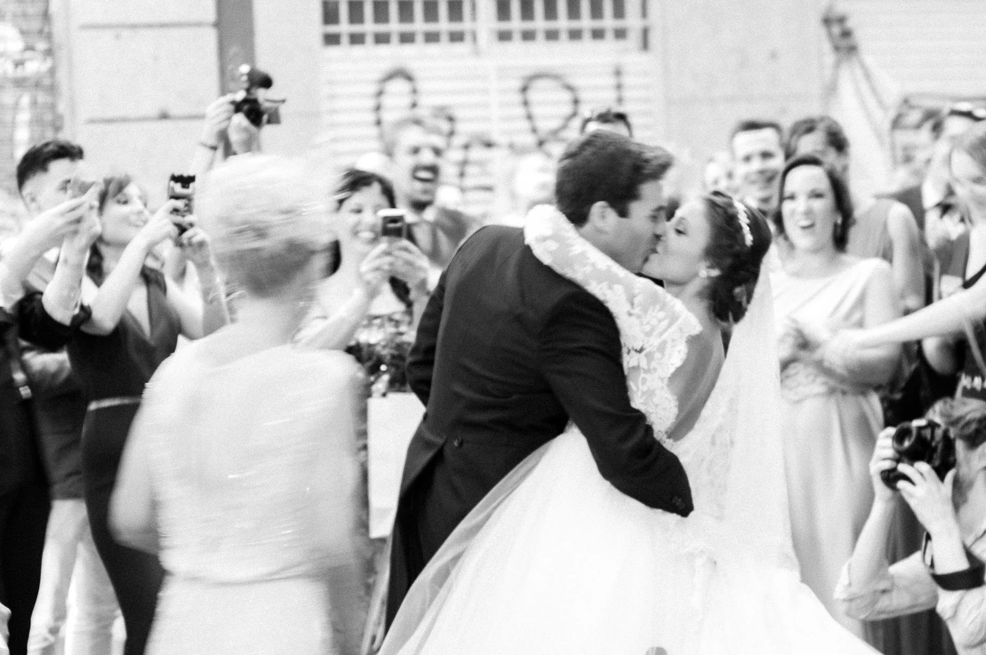 A bride and groom kiss in front of their friends and families in the centre of the city in Madrid Spain.