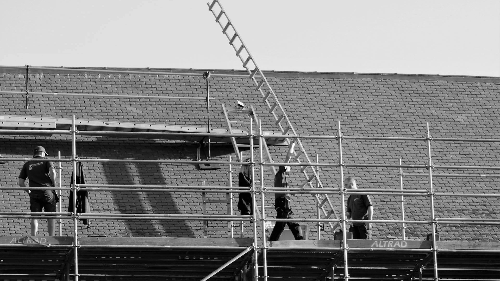 Contractors setting up scaffolding on a building