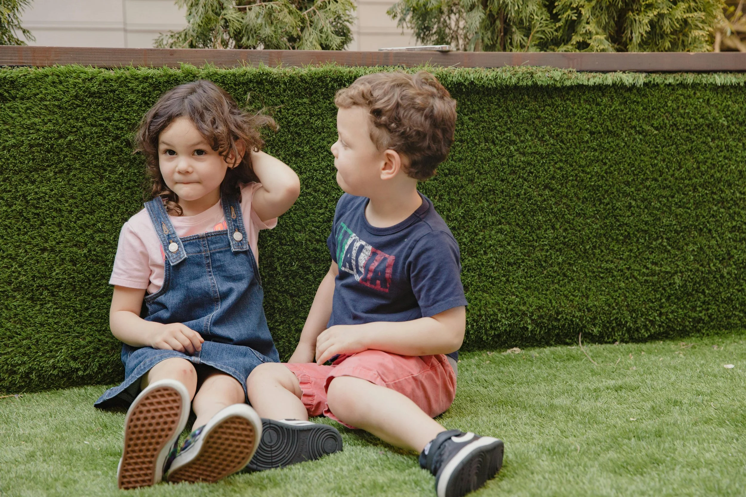a girl and a boy sitting next to each other. The boy is looking at the girl trying to connect