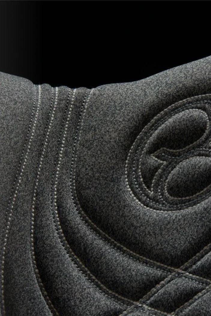 Close-up of black rolled-up yoga mat with textured surface and detailed stitching.
