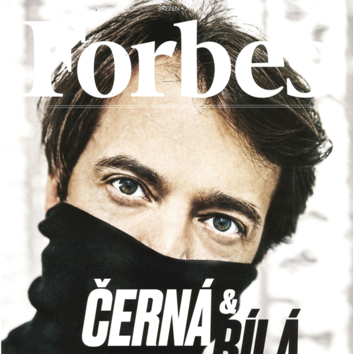 Close-up of a young man with blue eyes, dark hair, and a black face covering, on the cover of Forbes magazine with the title in Czech or Slovak language.