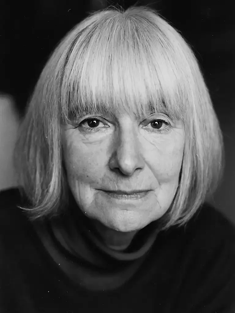 Schwarz-Weiß-Foto einer älteren Frau mit geradem, seitlich getragenem grauem Haar und einem schwarzen Pullover.