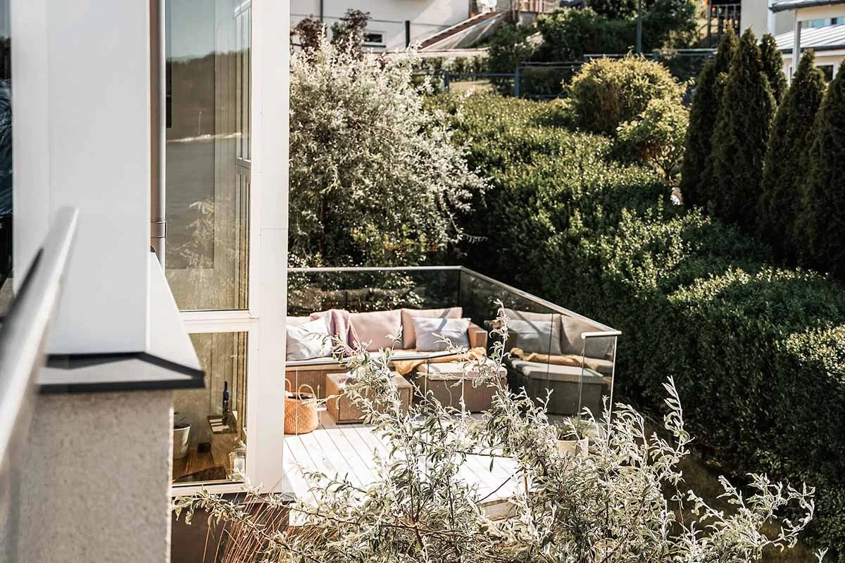 Homestyling Lidingö. Uteplats med loungemöbler i trägård.