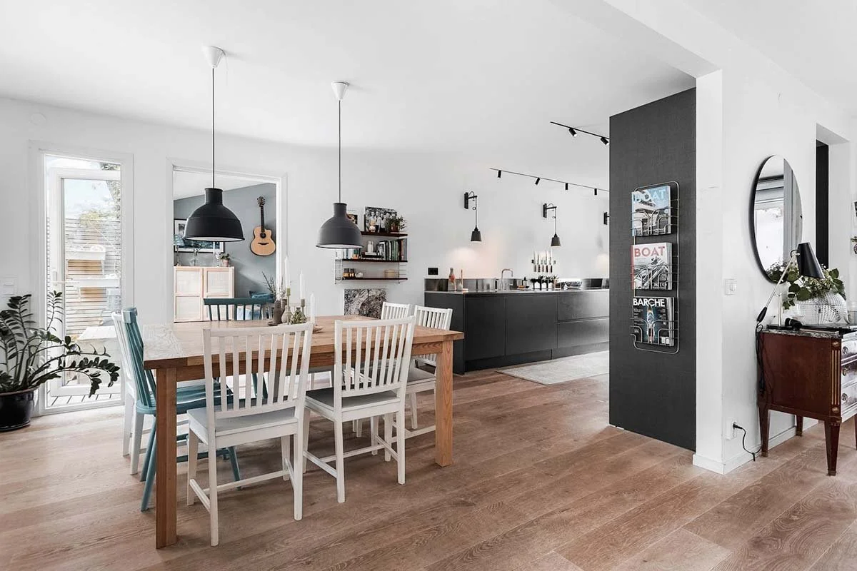 Homestyling Lidingö. En matplats och kök med taklampor över bord och köksbänk