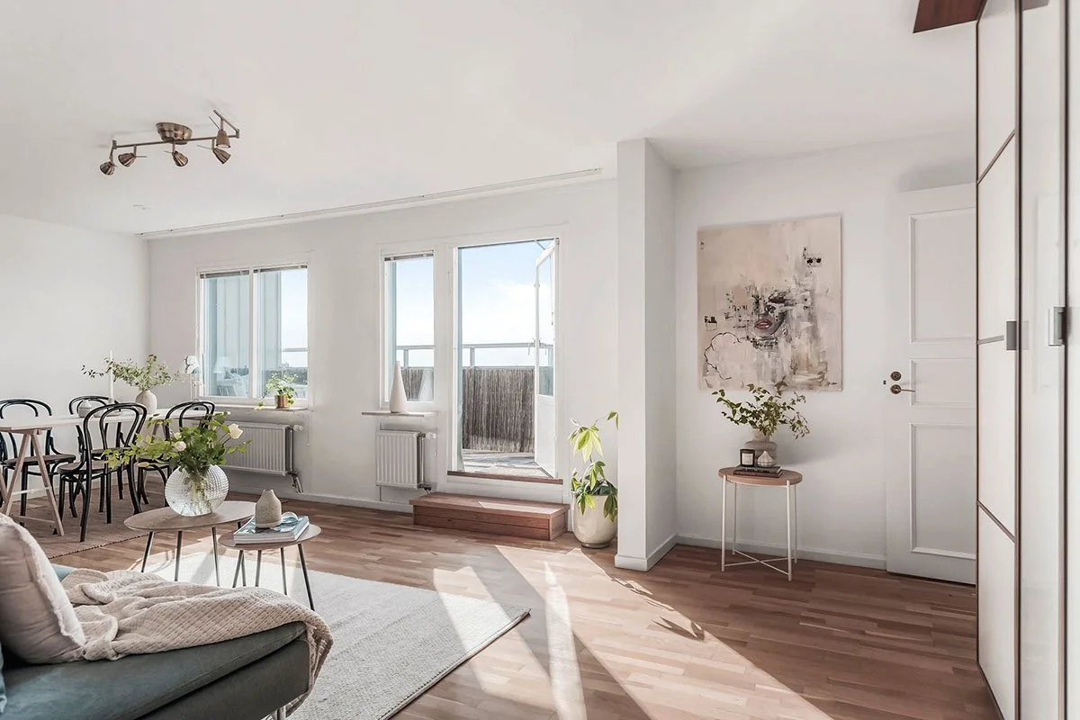 Ljus och luftig, omöblerad lägenhet stylad med moderna möbler och ljusa trägolv – homestyling på Lidingö inför fotografering.