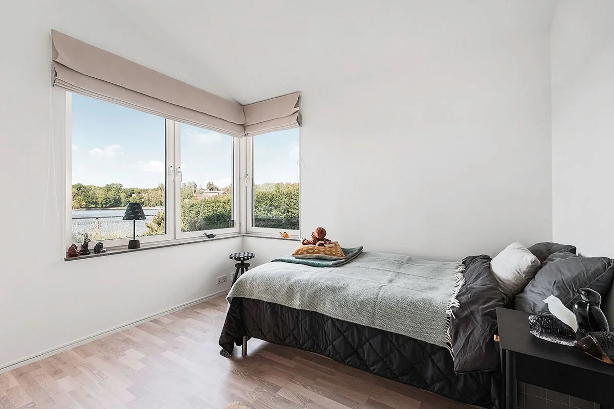 Homestyling Lidingö. Ljust sovrum med säng och stora fönster