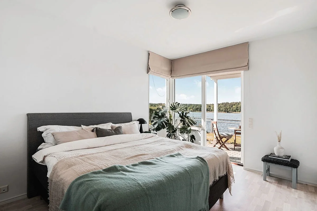 Homestyling Lidingö. Modernt, ljust sovrum med säng och stora fönster
