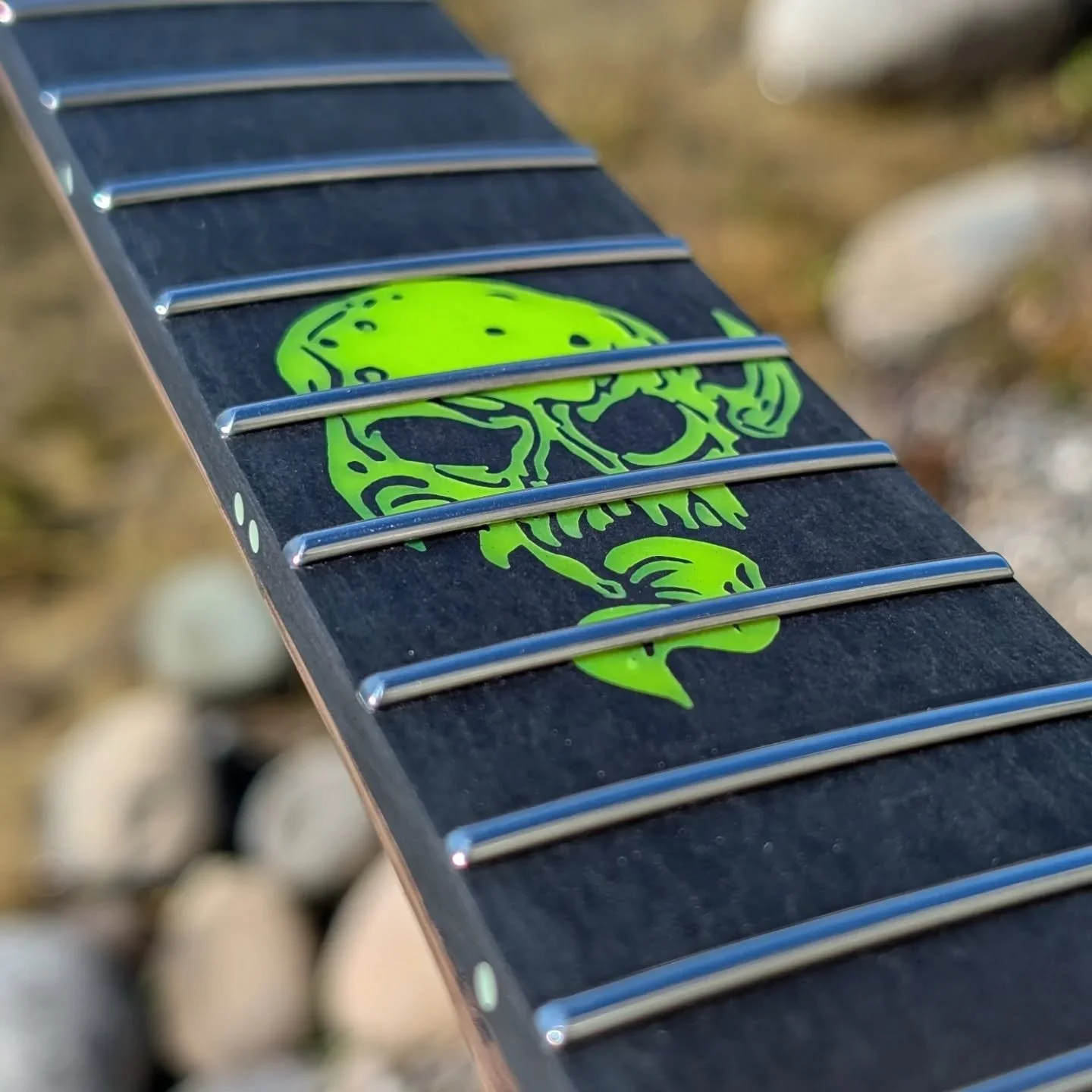 Richlite with toxic green glow-in-the-dark inlay. And of course shiny stainless steel frets! 
@anton_graves