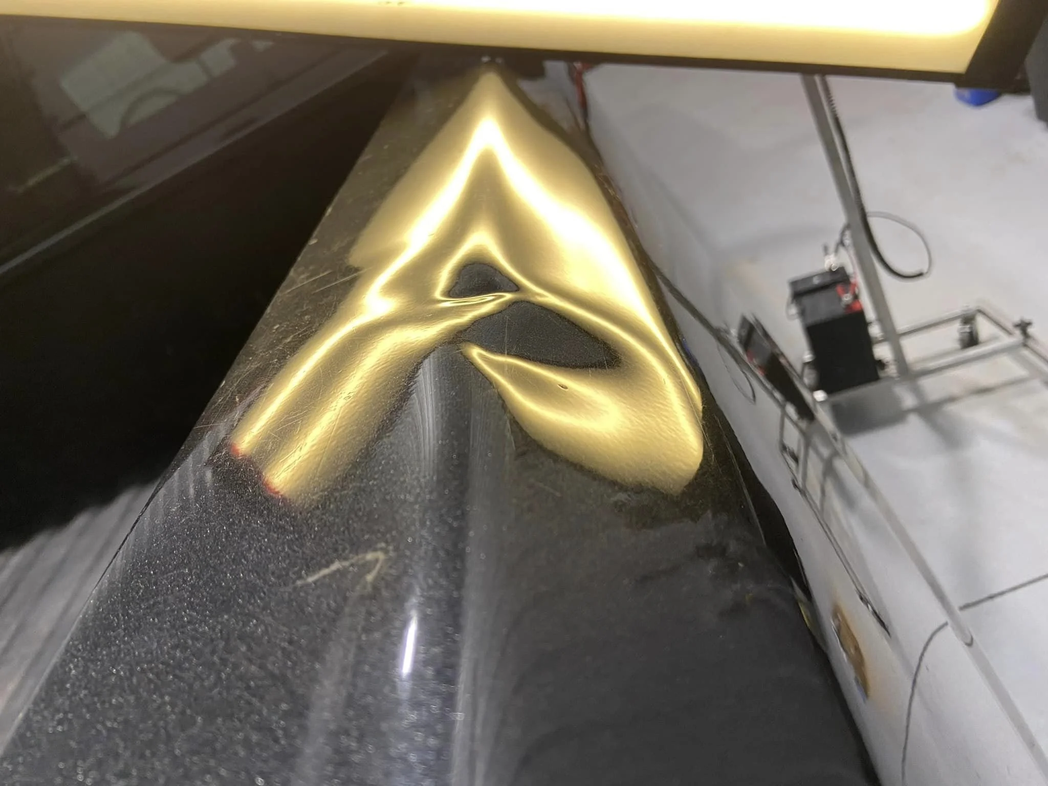 Close-up of a car with a dent that is being repaired with paintless dent repair (PDR).