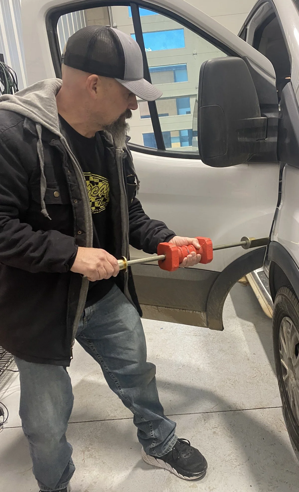 Ryan using paintless dent repair to fix a dent on a white truck