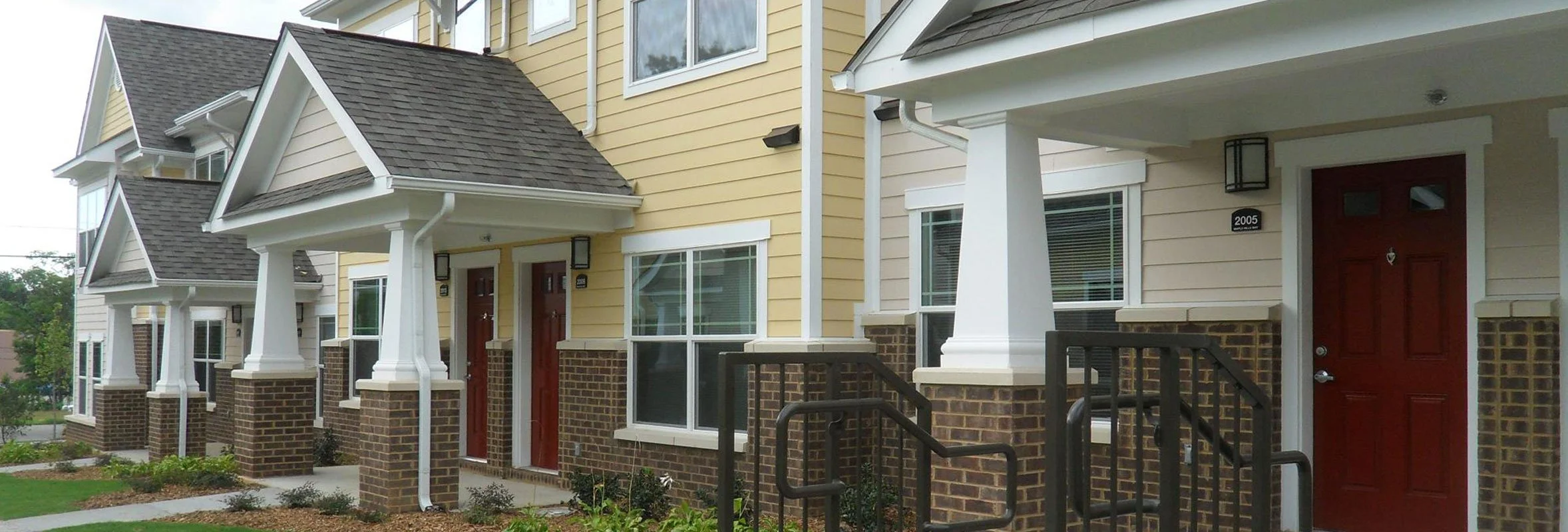 Townhouse building with brick pillars and red doors