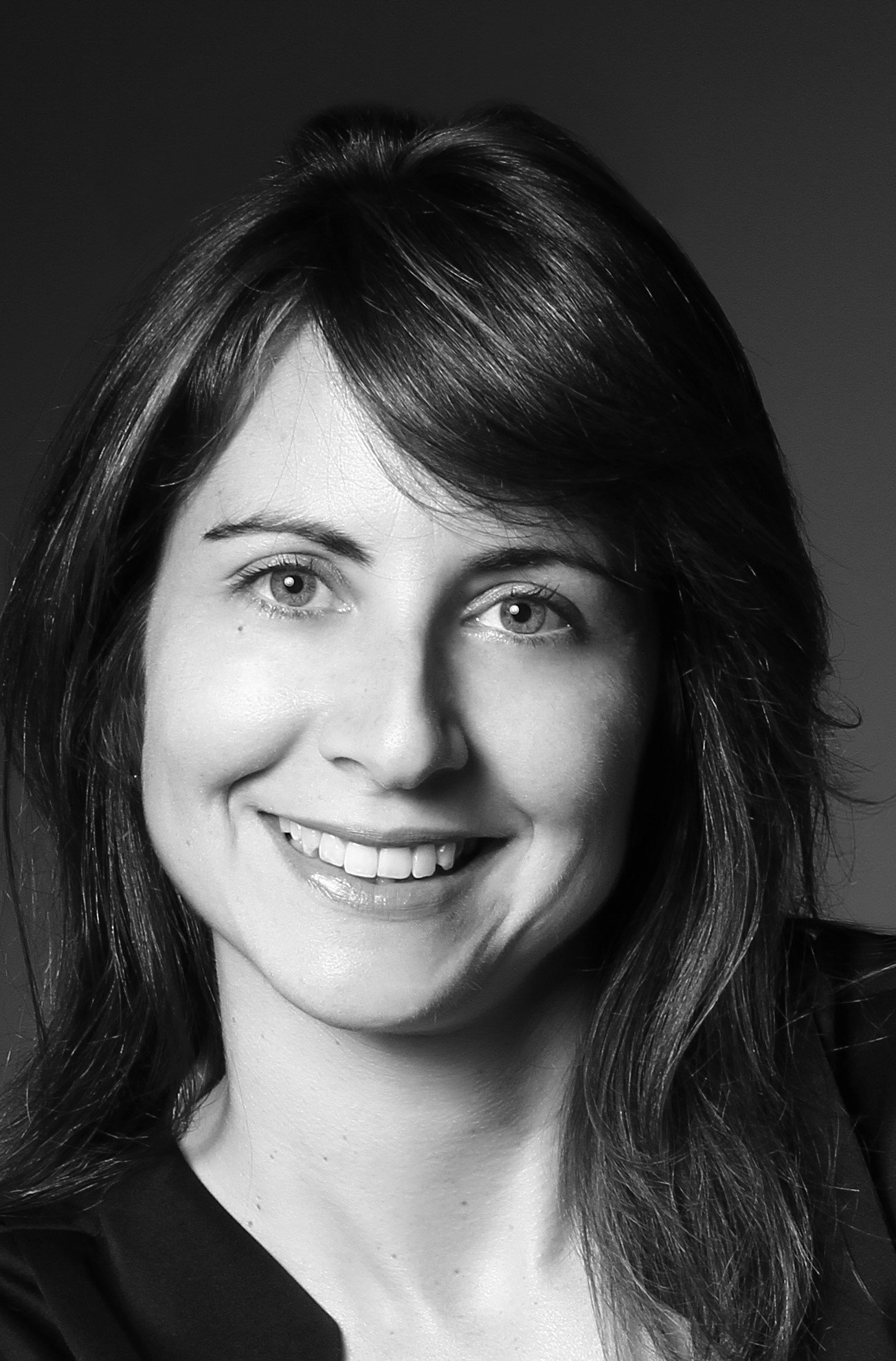 Black and white portrait of a smiling woman with shoulder-length hair.