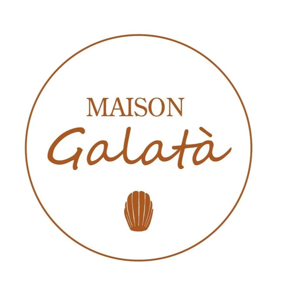 A circular logo for Maison Galatà with the text in brown, featuring the word 'Maison' in uppercase and 'Galatà' in a script font, with a small brown seashell icon below the text.