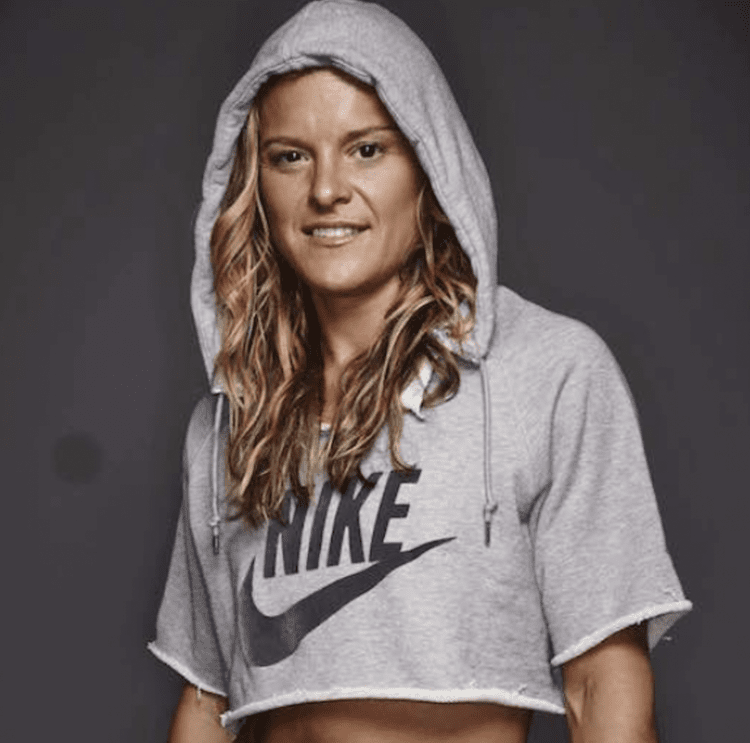 Blonde woman with brown eyes wearing a grey Nike hoodie