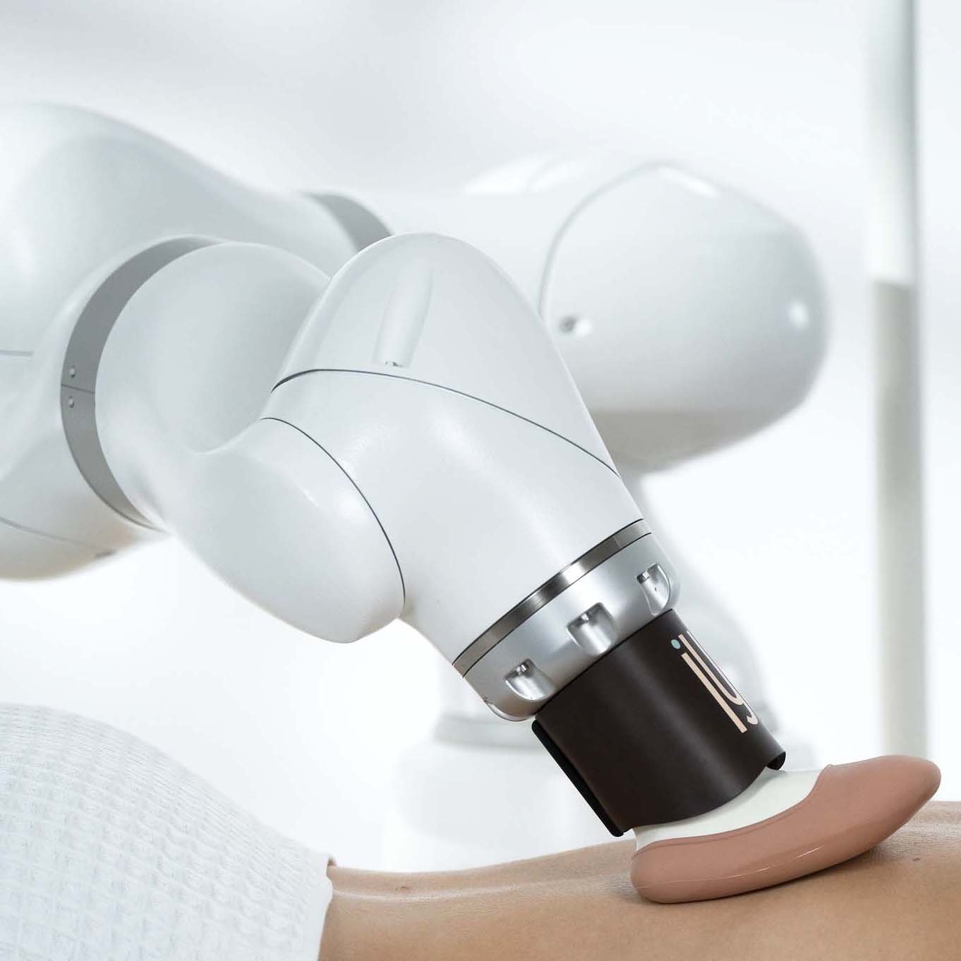A medical robotic arm performing a procedure on a patient's arm.
